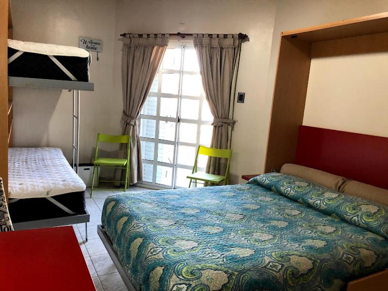 ein Schlafzimmer mit einem Bett und einem großen Fenster in der Unterkunft departamento acosta 2 in Paraná