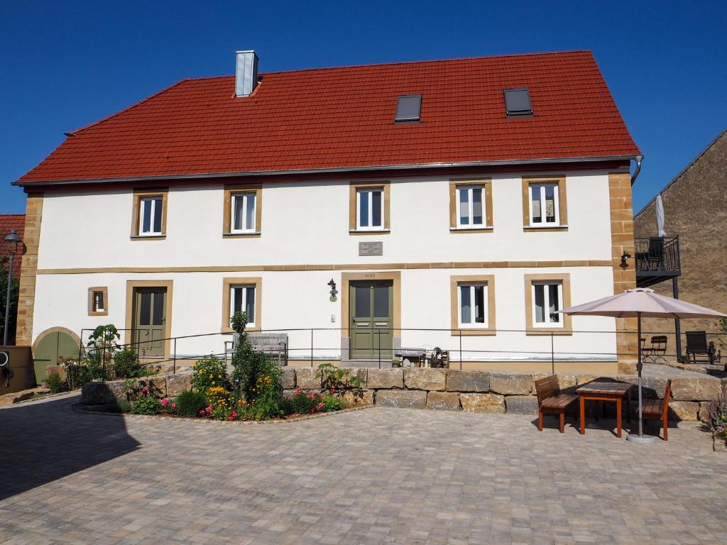 a large white house with a red roof at Ferienwohnungen Grüner Baum in Seinsheim