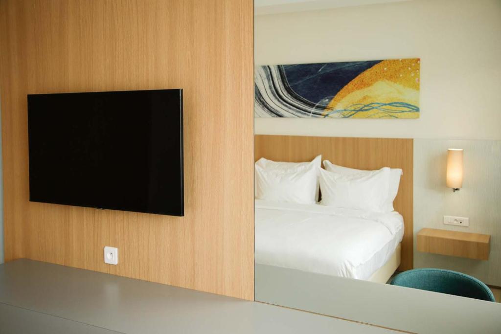 a hotel room with a bed and a flat screen tv at Zephyr Agadir in Agadir