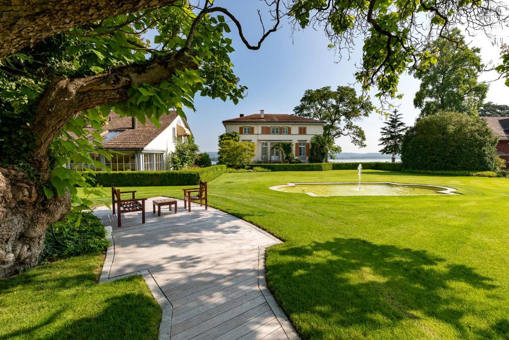 un giardino con due panchine e una casa di LILIENBERG a Ermatingen
