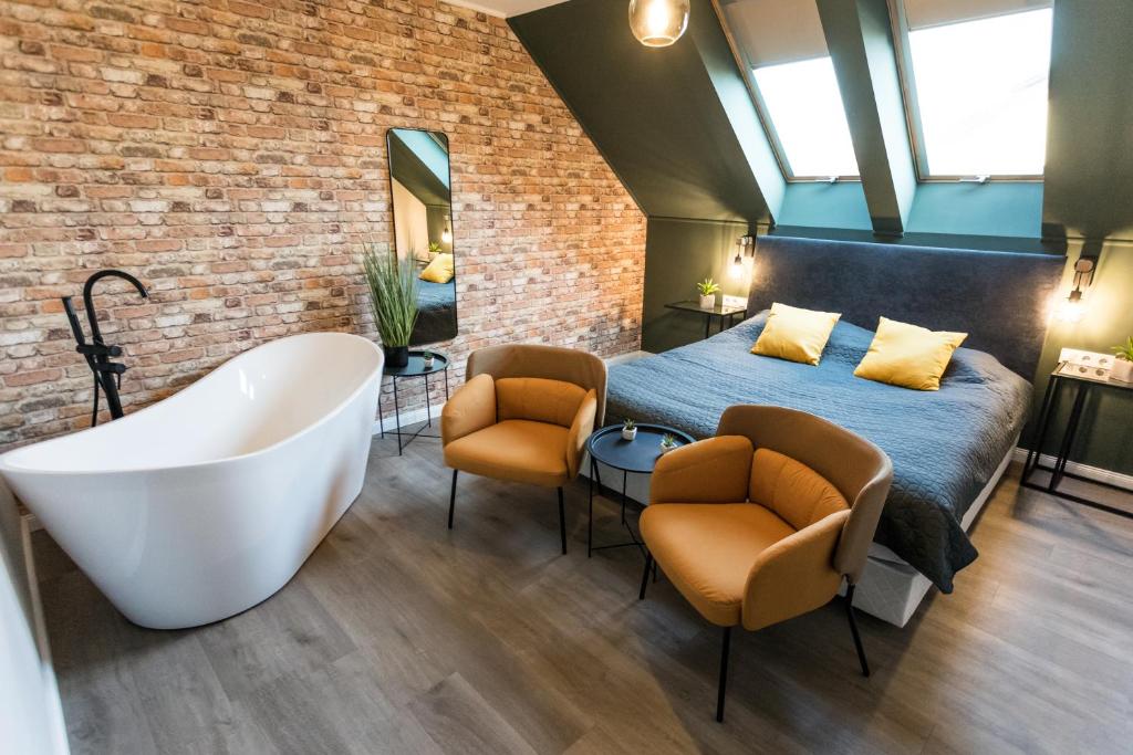 Deluxe Thermal Resort في بابا: غرفة نوم مع سرير وحوض استحمام