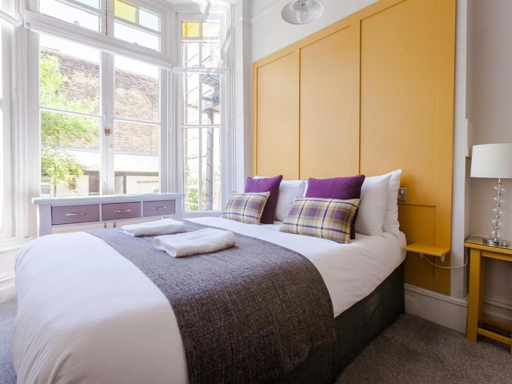 a large bed in a room with a large window at Regency House in Cambridge