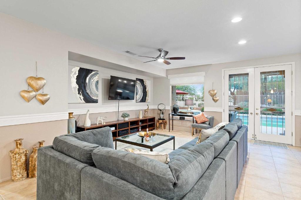 a living room with a couch and a tv at Pool and Spa Home on Golf Course in Surprise! in Surprise