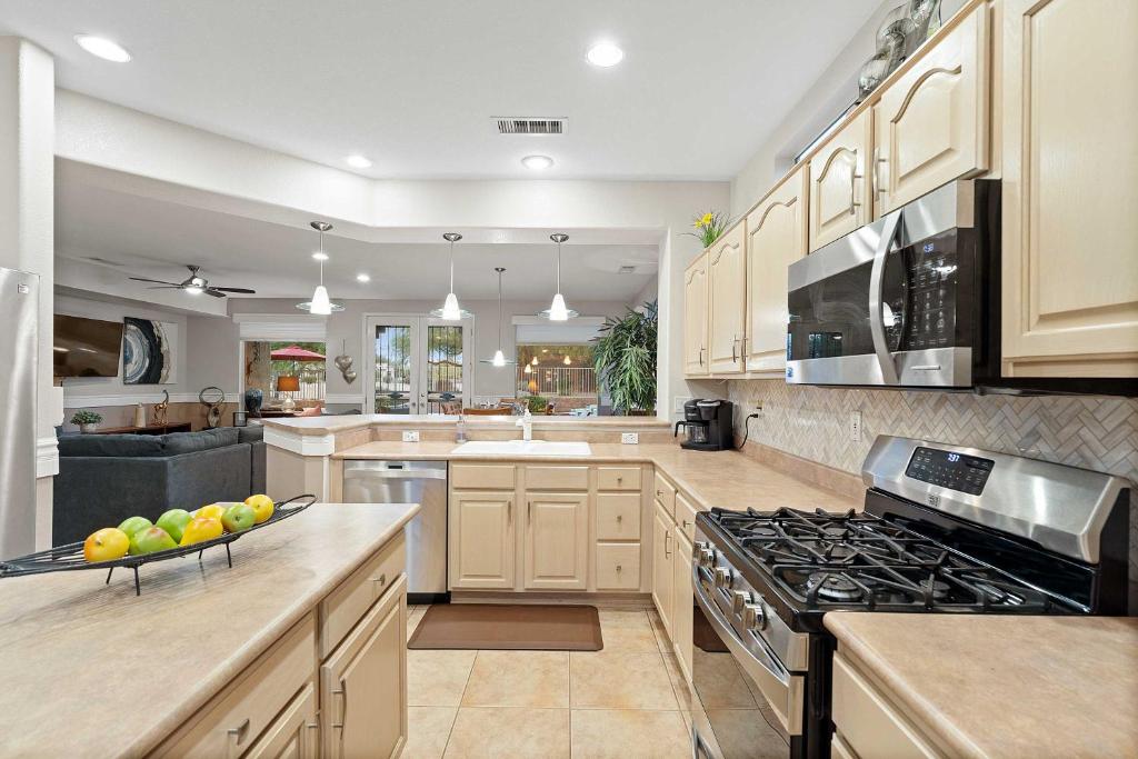 eine Küche mit weißen Schränken und einem Herd mit Backofen in der Unterkunft Sun City Grand Golf Course Gem with Pool, Spa and Cart in Surprise