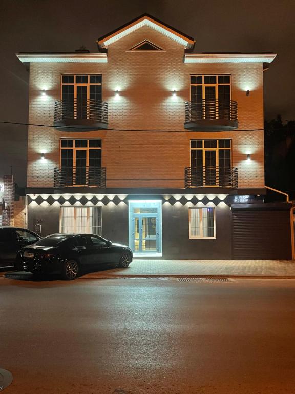 um carro estacionado em frente a um edifício à noite em AREDO HOTEL em Rostov on Don