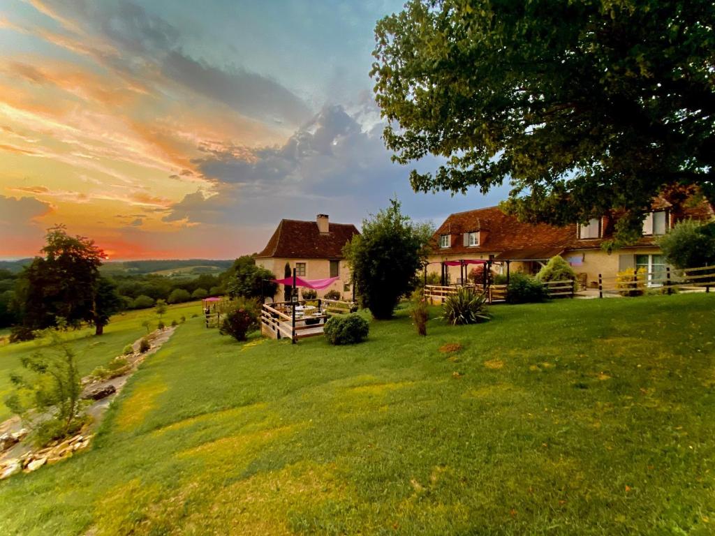una casa en una colina de hierba con una puesta de sol en Le Clos Romantic & Spa - Périgueux - Bassillac et Auberoche, en Eyliac