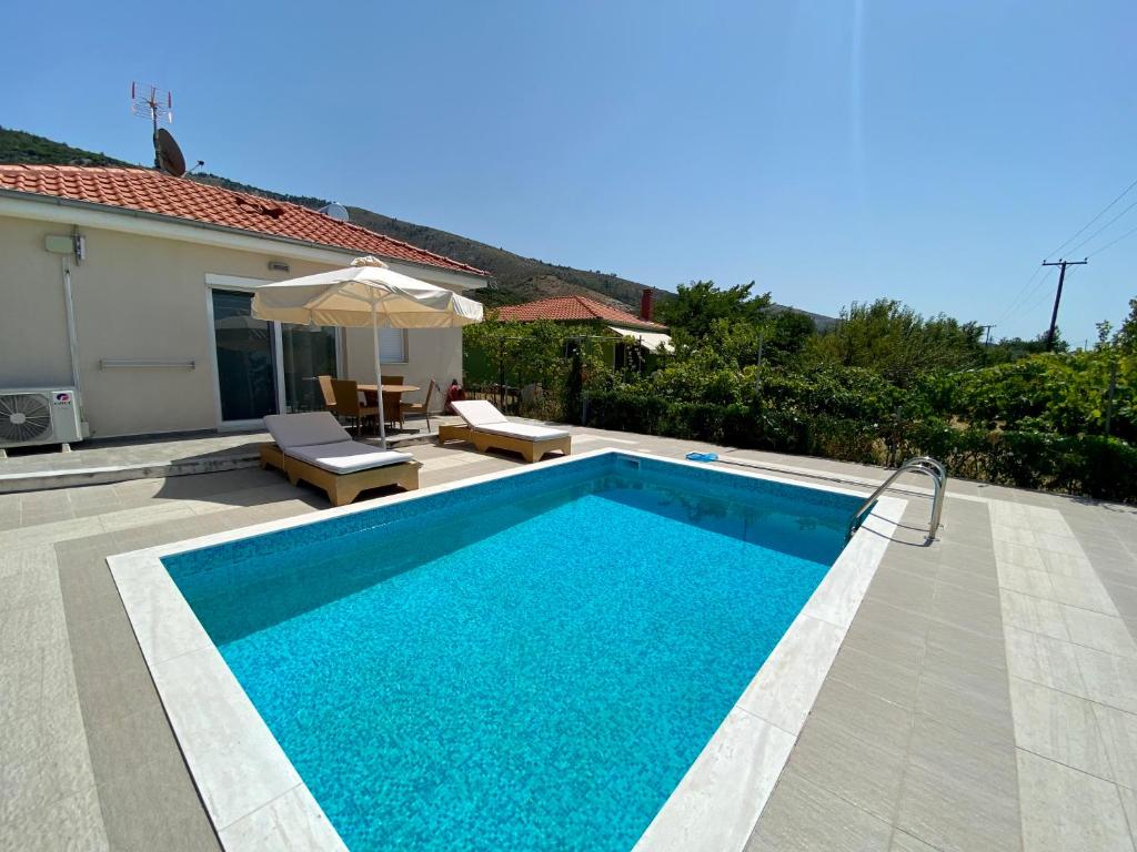 a swimming pool in front of a house at Alea Villa in Skala Rachoniou