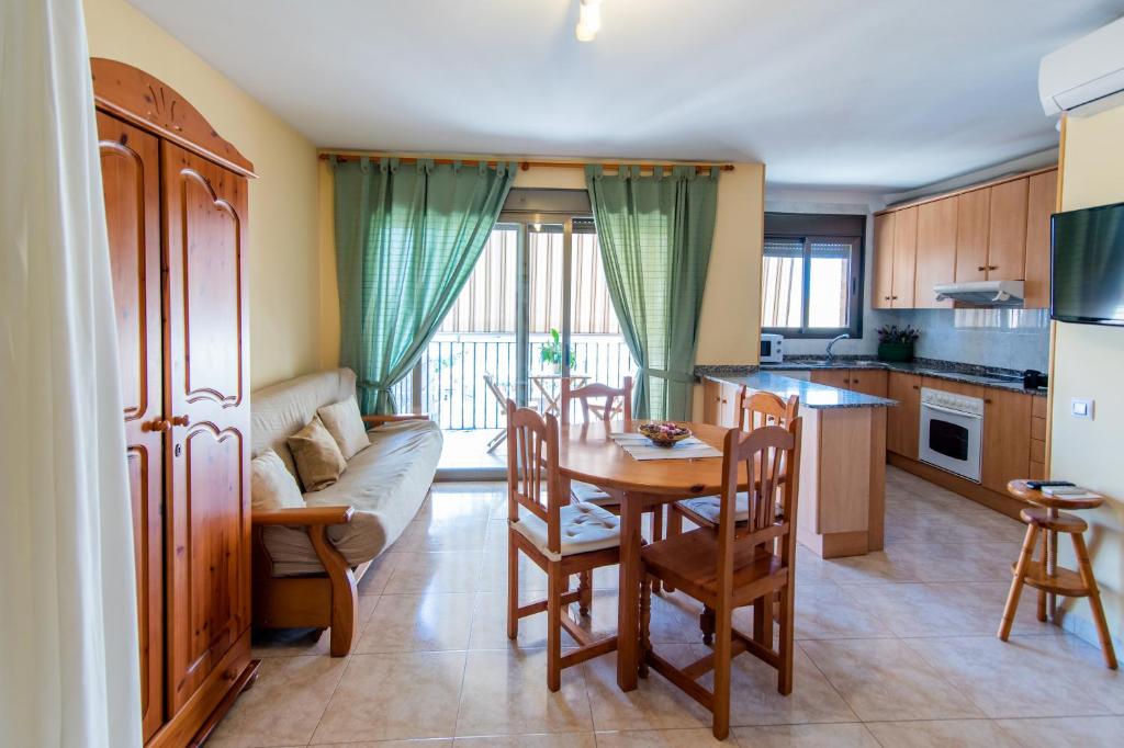 cocina y sala de estar con mesa y sofá en Apartamentos Maribel, en Calaceite