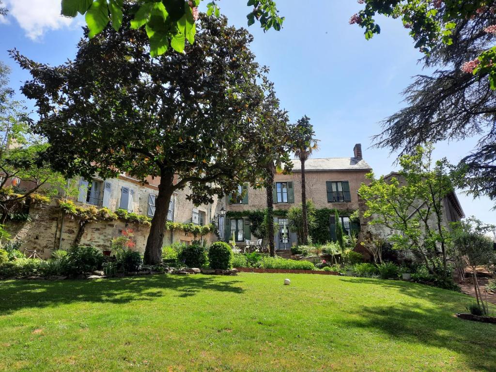 ein großes Haus mit einem Baum im Hof in der Unterkunft Les Cèdres in Montaigu-Vendée