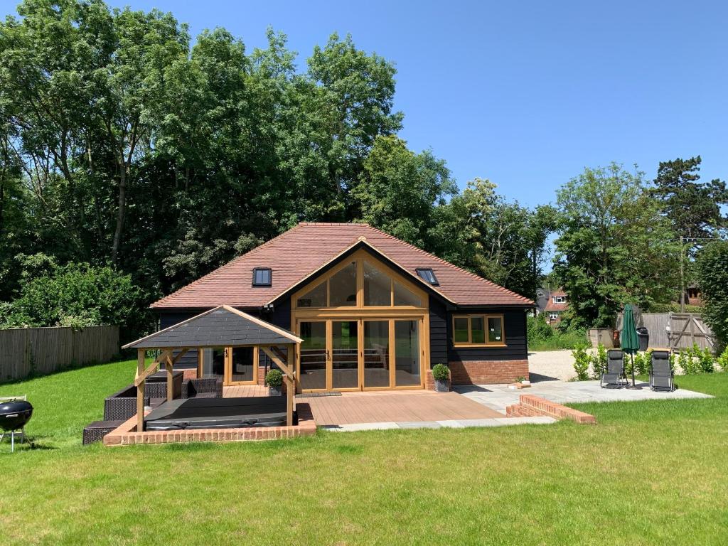 una pequeña casa con un gran porche en un patio en Chestnut-Lodge is rural, secluded, private with Hot Tub, en Maidstone