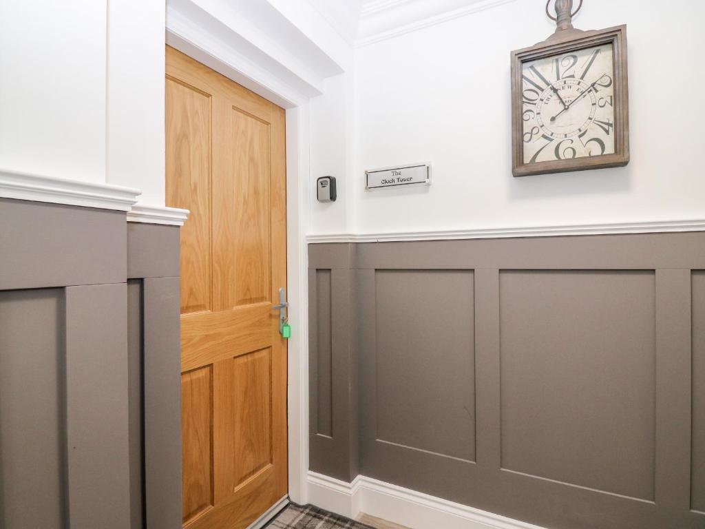 a hallway with a gray garage door and a clock on the wall at The Clock Tower at The Institute Executive Apartments in Keith