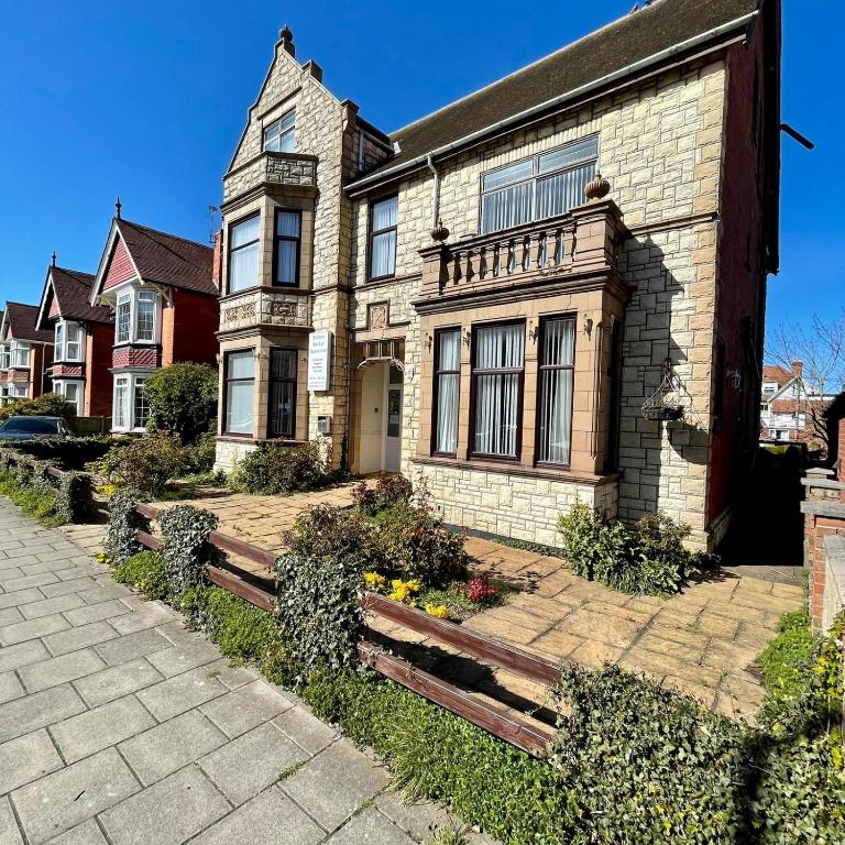 a large brick house with a pathway in front of it at Lyndene Holiday Apartments in Skegness