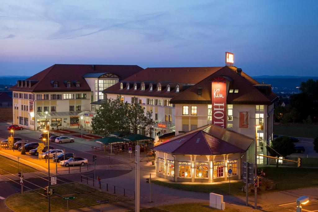 een groot gebouw met een bord op een parkeerplaats bij Kim Hotel Dresden in Dresden