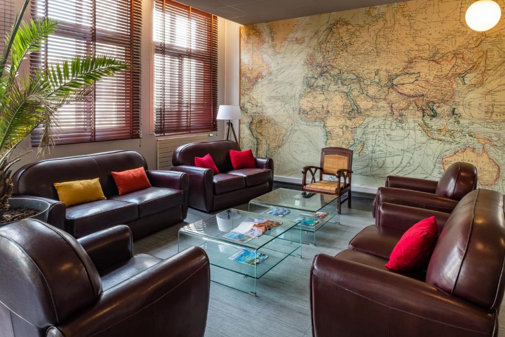 a living room with leather furniture and a large map at Smartappart Lorient in Lorient