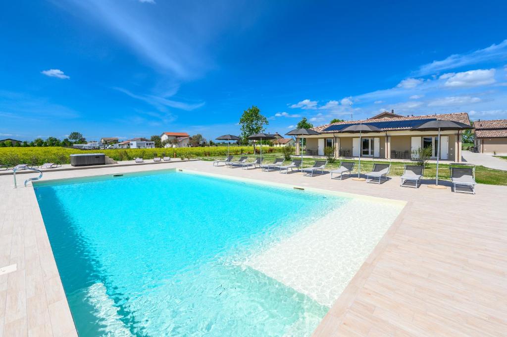 a swimming pool with chairs and a house at Terra Fina in Savio di Ravenna