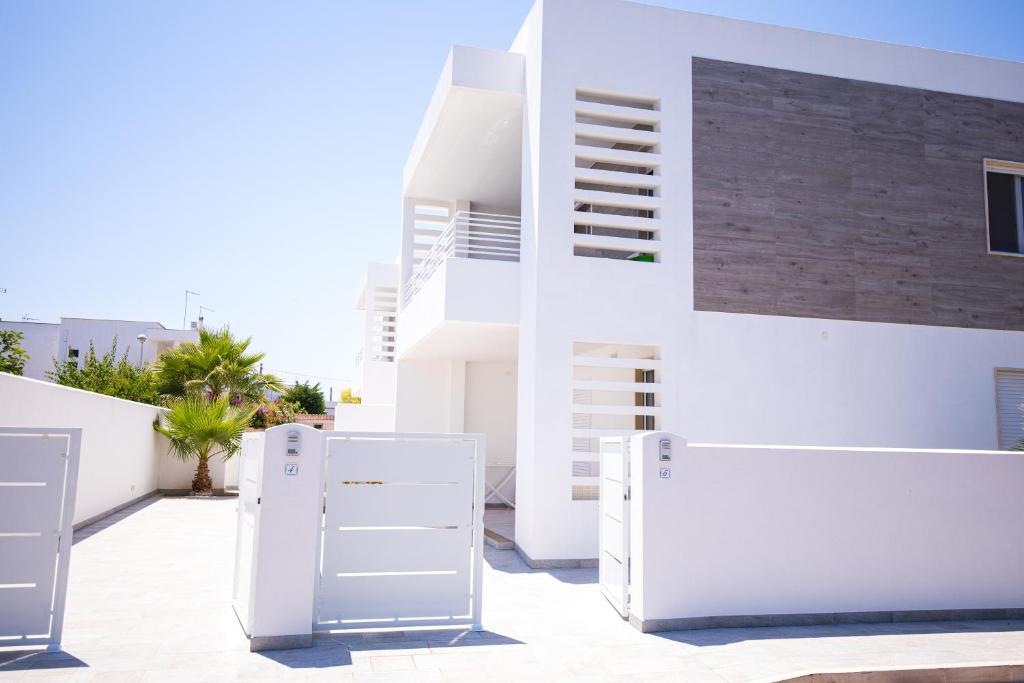 a white building with white furniture in front of it at Donnosanto Residence Pantanagianni in Torre Santa Sabina