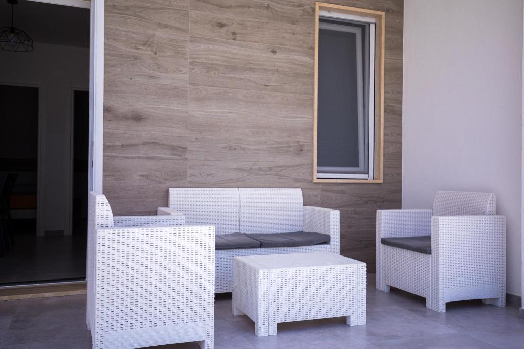 a group of white chairs and a table at Donnosanto Residence Pantanagianni in Torre Santa Sabina