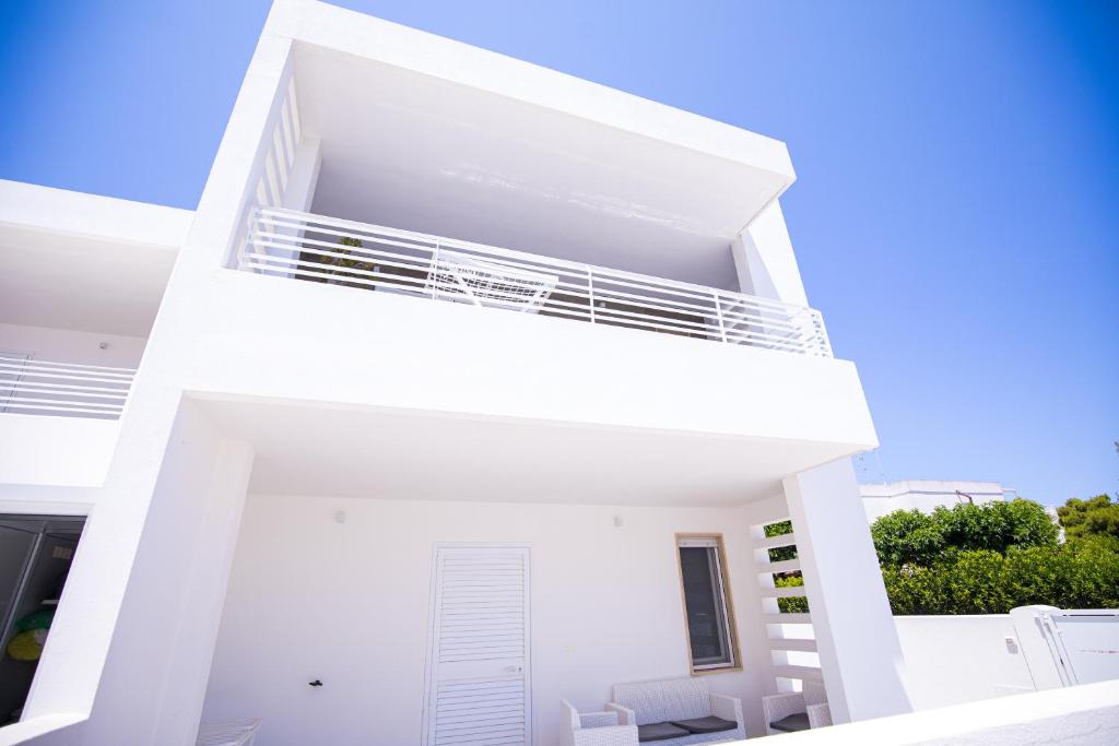 a white apartment building with a balcony at Donnosanto Residence Pantanagianni in Torre Santa Sabina