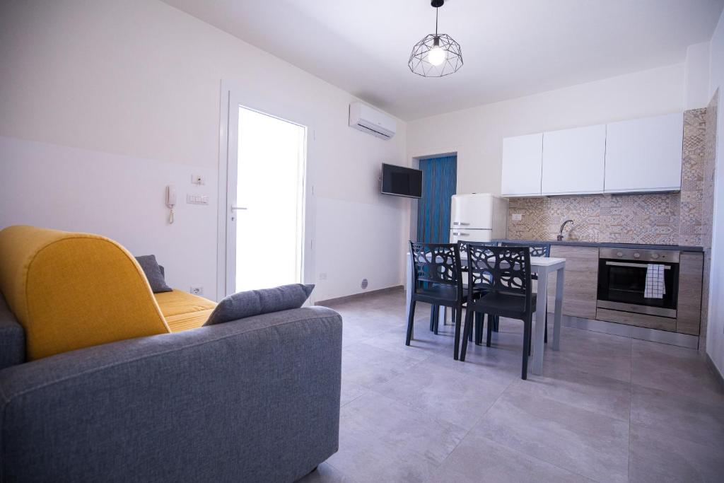 a living room with a couch and a table and a kitchen at Donnosanto Residence Pantanagianni in Torre Santa Sabina