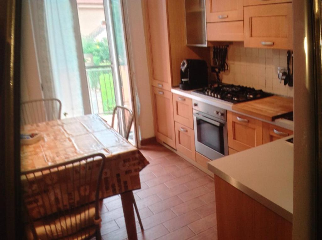 uma cozinha com uma mesa e um fogão forno superior em Baita Milgra em Riccò del Golfo di Spezia