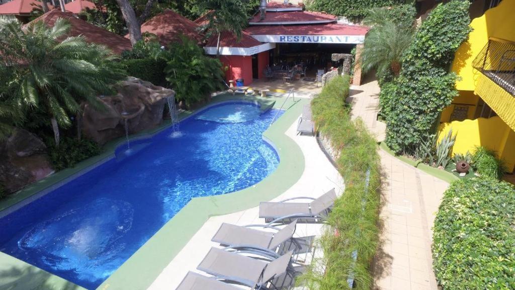 einem Pool mit Liegestühlen und einem Resort in der Unterkunft Mangaby Playa Hermosa in Playa Hermosa