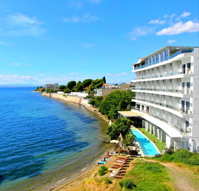 a hotel on the beach next to the water at Porto Evia Boutique Hotel in Amarynthos