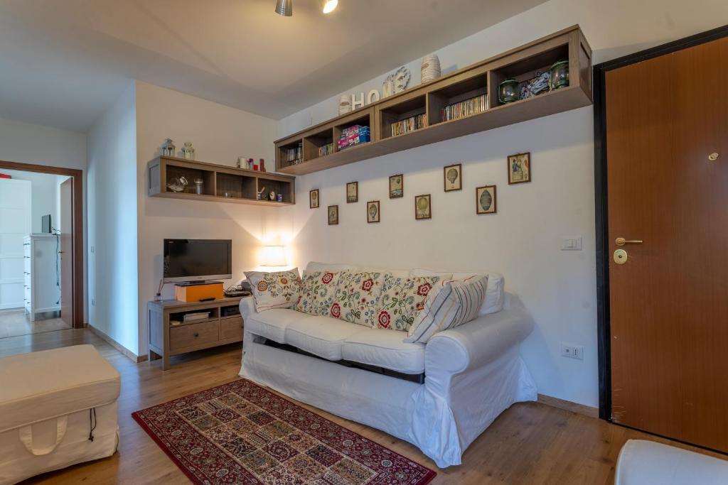 een woonkamer met een witte bank en een tafel bij Cave del Predil Lovely Apartments in the Julian Alps in Cave del Predil