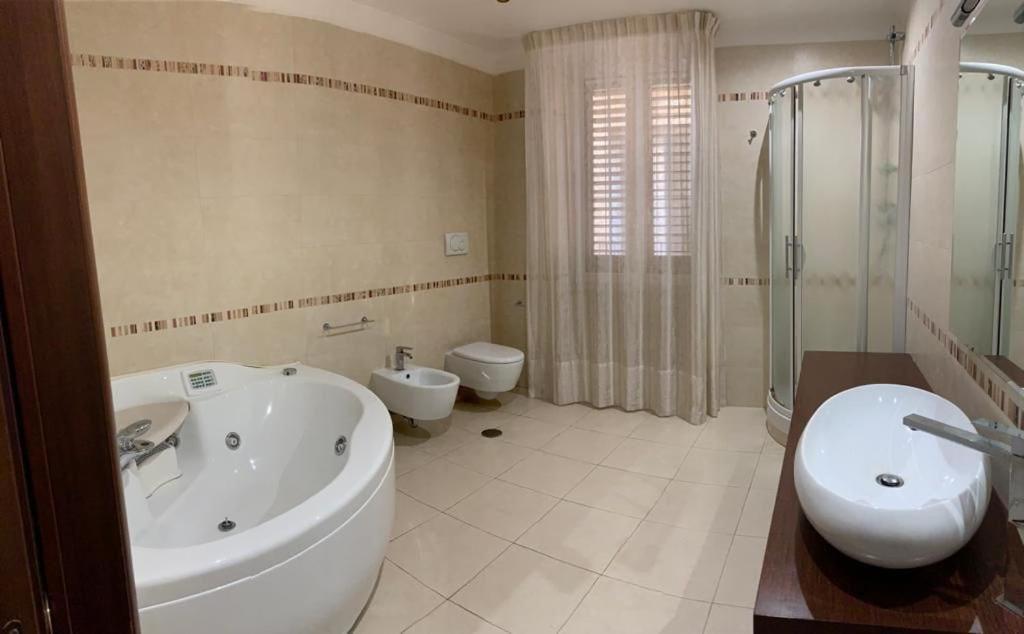 a bathroom with a tub and a sink and a toilet at Suite San Cataldo in Taranto