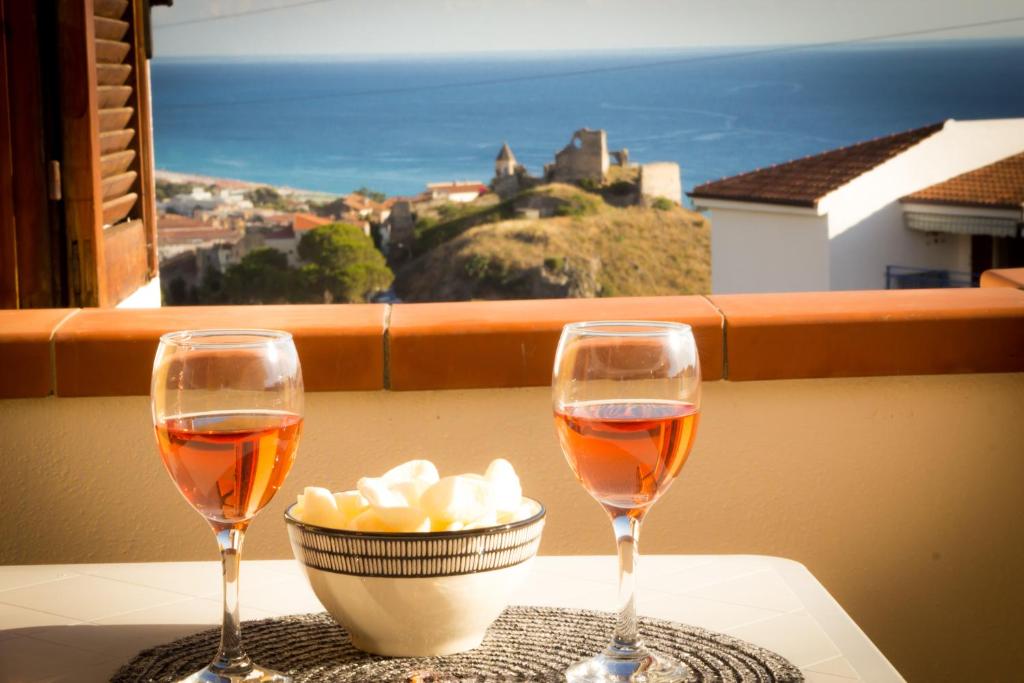 due bicchieri di vino e una ciotola di cibo su un tavolo di Calabria Dream Holiday Home a Scalea