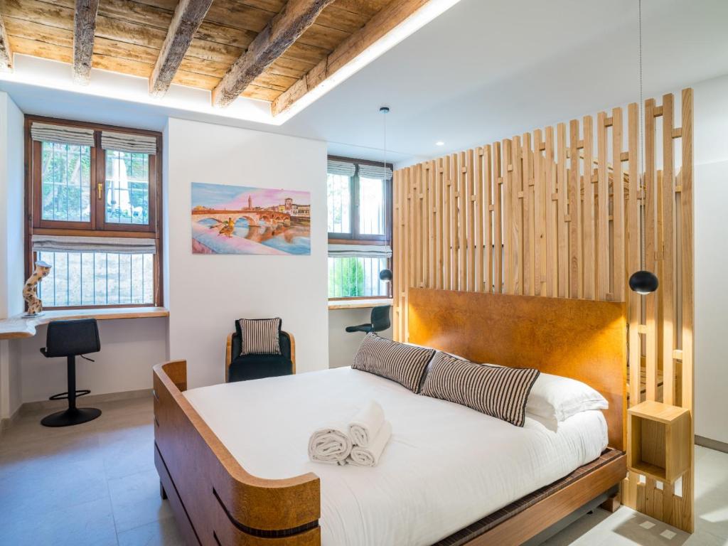 a bedroom with a bed with a wooden headboard at Design Rooms Verona in Verona