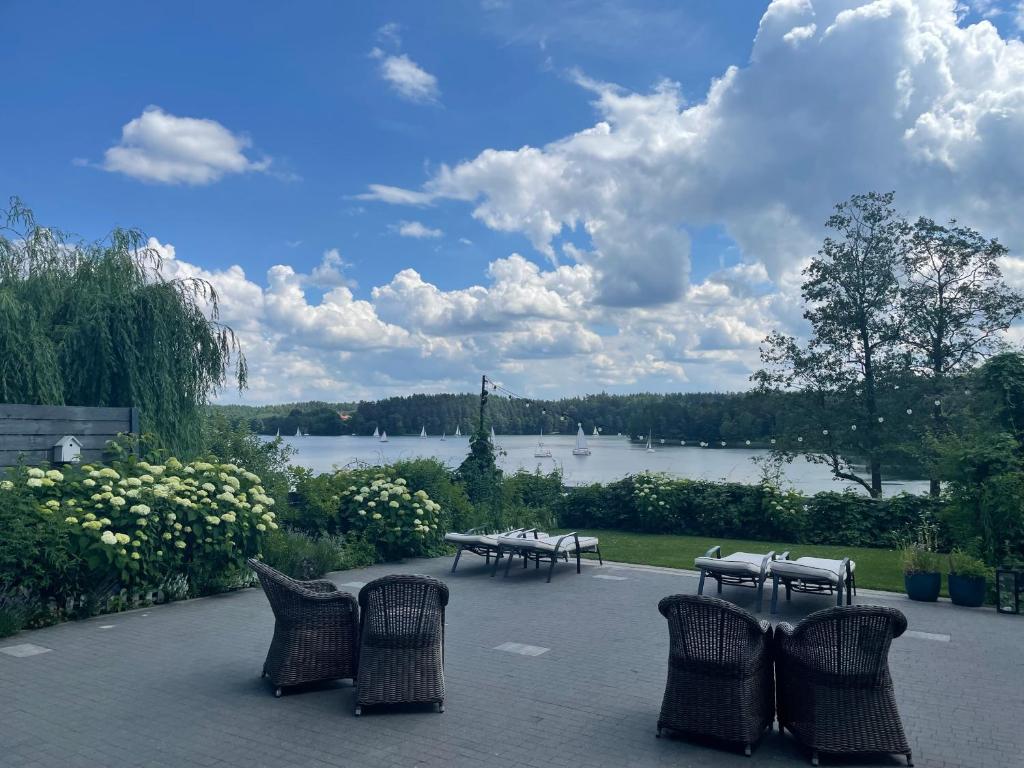 a group of tables and chairs in front of a lake at Dom Wiejska 39 a in Ruciane-Nida