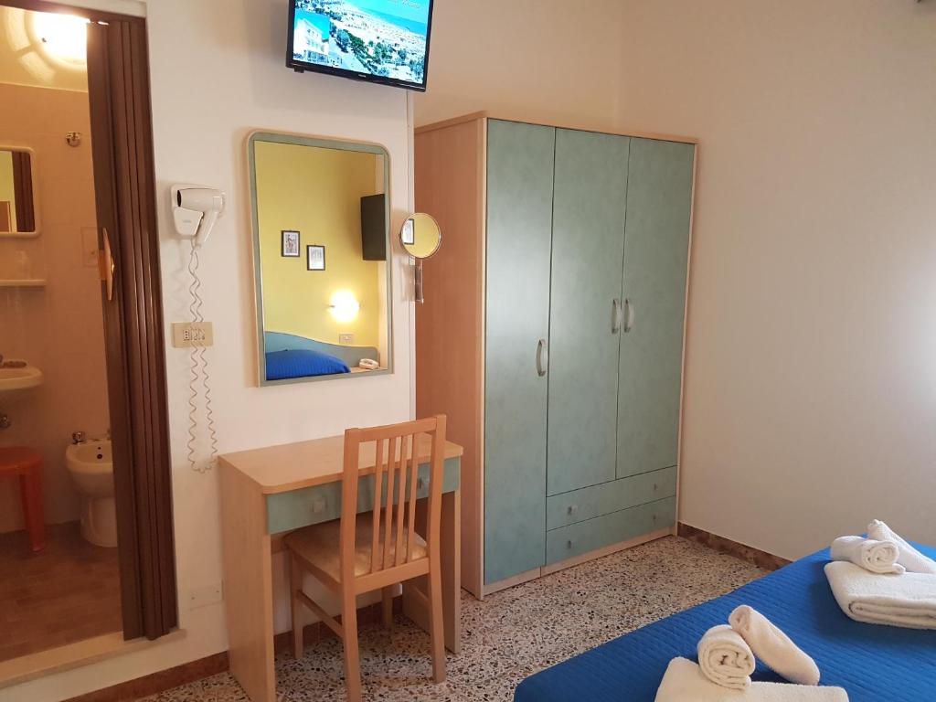 Hotel Villa Ersilia Rimini B&B في ريميني: غرفة نوم مع مكتب وطاولة ومرآة