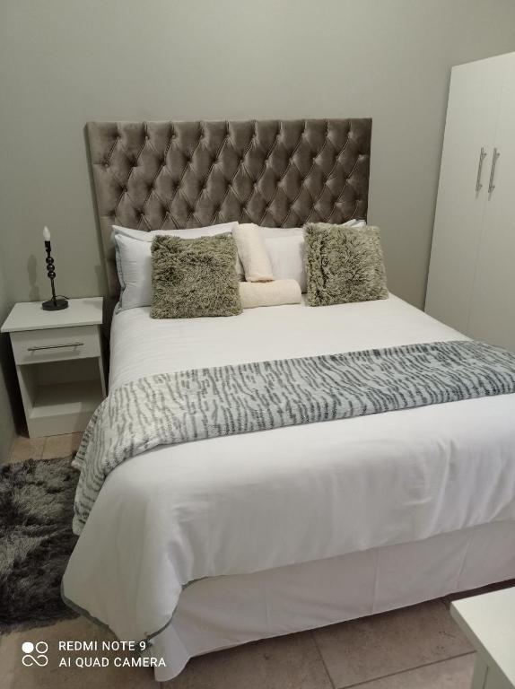 een slaapkamer met een groot bed met een groot hoofdeinde bij Atholl Heights Homee in Westville