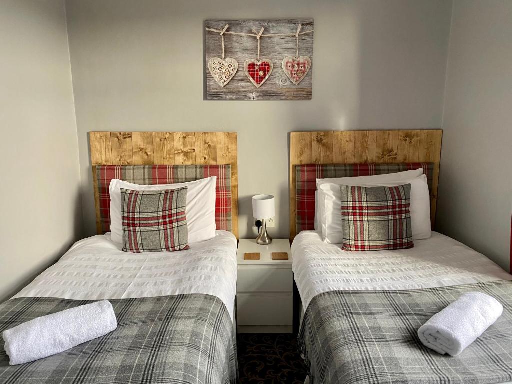 two beds sitting next to each other in a room at Number 19 Guest House in Barrow in Furness