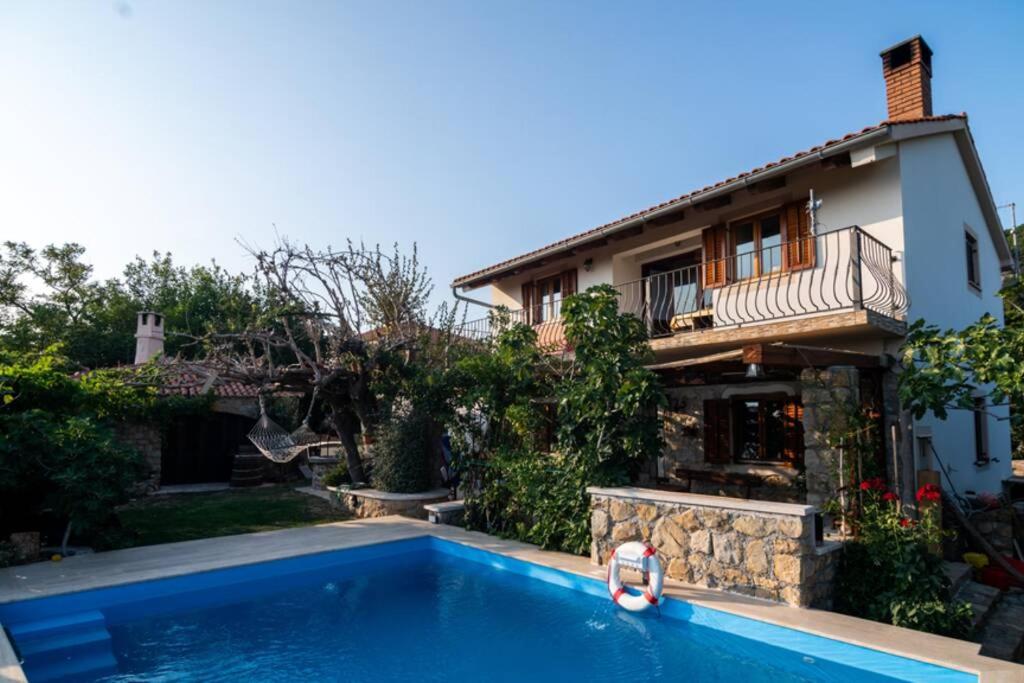 una casa con piscina frente a una casa en Etno Villa with a pool - Matušanovi Dvori Rab, en Rab