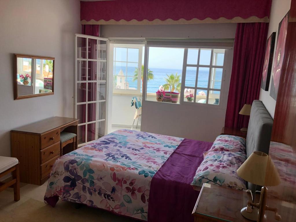 1 dormitorio con cama y ventana con vistas al océano en Chaparil, en Nerja