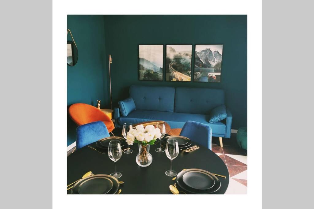 a dining room with a table and a blue couch at L'edelweis in Le Bourg-dʼOisans