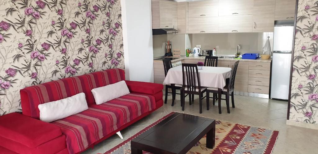 a living room with a red couch and a table at Comfort Apartments in Fier