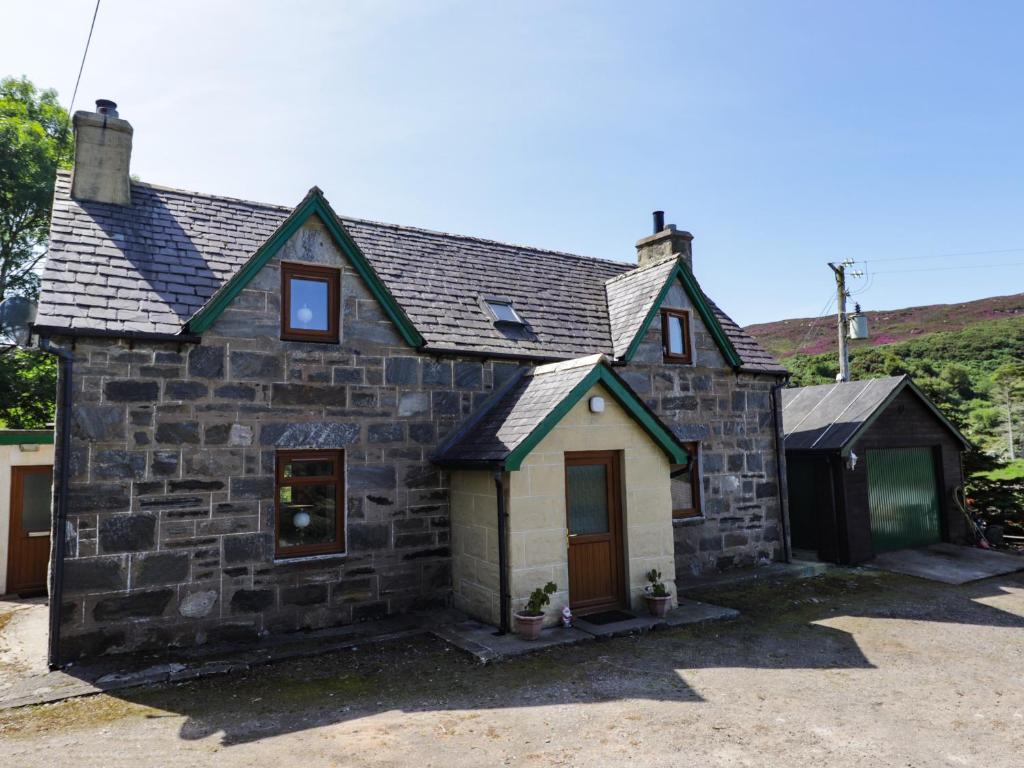 een klein stenen huis met een garage bij 8 Achnabat in Thurso