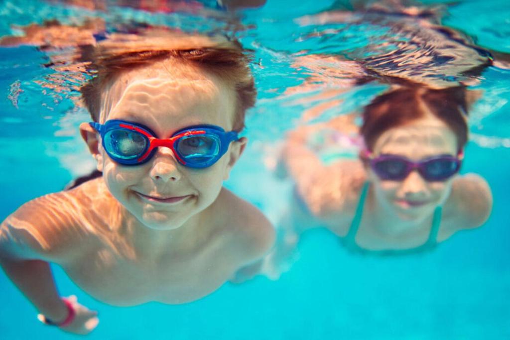 dos niños pequeños con gafas en una piscina en Chasna, en Costa del Silencio