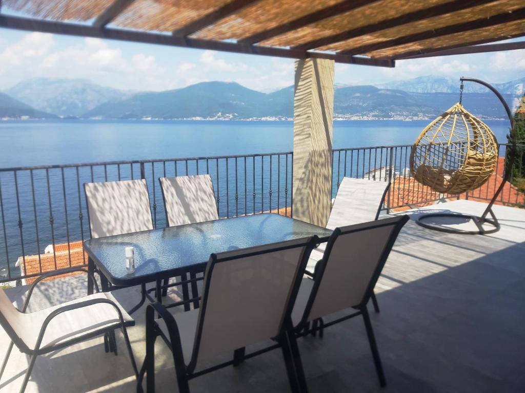 a table and chairs on a balcony with a view of the water at Martin Lux Apartment in Krasici
