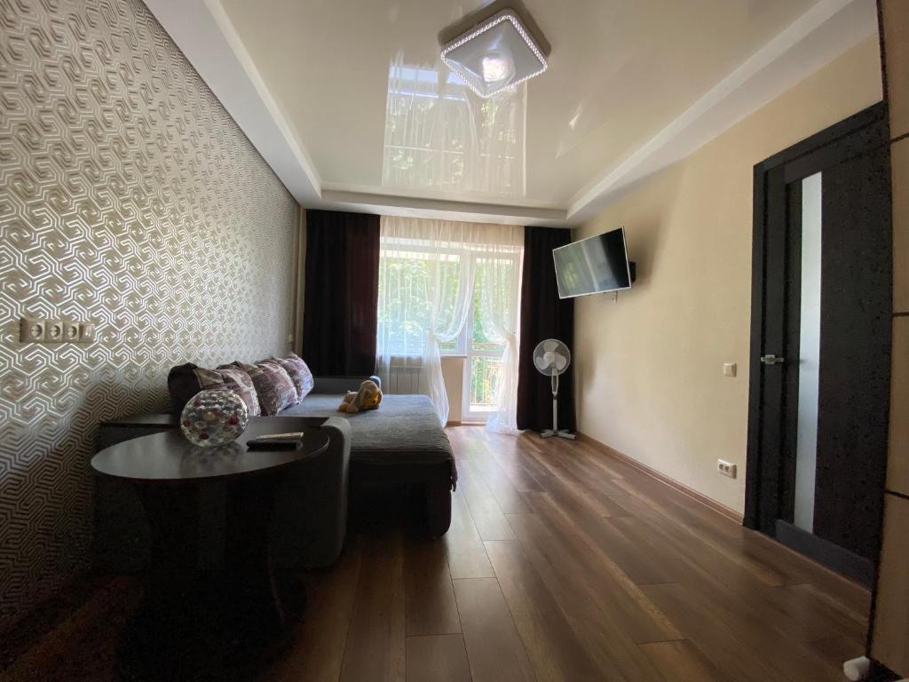 een woonkamer met een bank en een tafel bij Apartment 30 m2 on Sergei Esenin 11 in Charkov