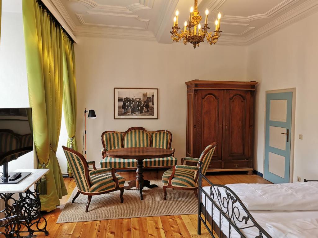 Schlafzimmer mit einem Bett, einem Tisch und Stühlen in der Unterkunft Altstadt Palais in Weimar