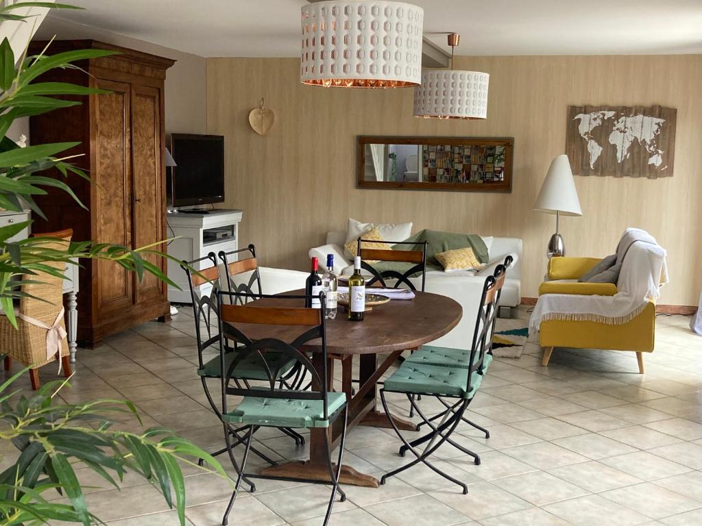sala de estar con mesa y sillas en La Casa Cantarana, en Le Teich