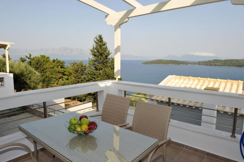 una mesa con un bol de fruta en el balcón en Lemon Tree en Nydri