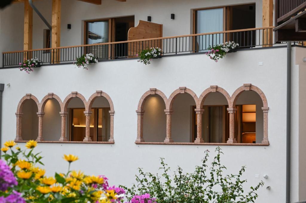 a facade of a building with windows and flowers at B&B Fontanella in San Lorenzo in Banale