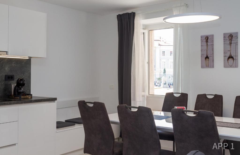 uma sala de jantar com mesa e cadeiras em Premium Tartini Apartment by Locap Group em Piran