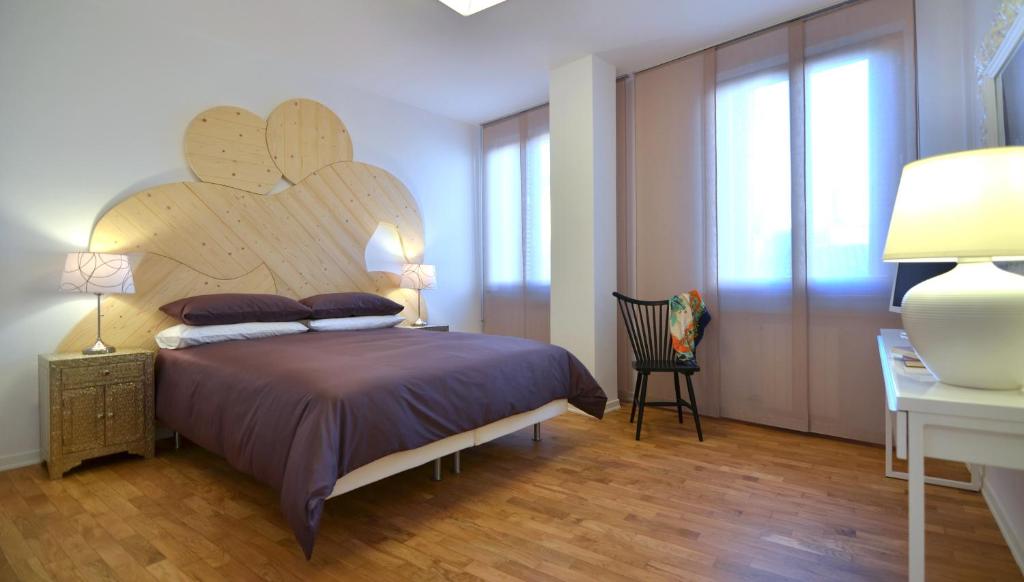 a bedroom with a large bed with a wooden headboard at Angelina Urban Lodge in Tolentino