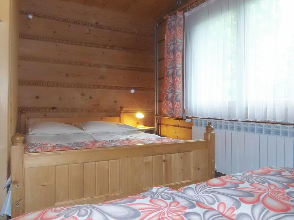 sypialnia z dużym łóżkiem i drewnianą ścianą w obiekcie U Justynki w Małym Cichym