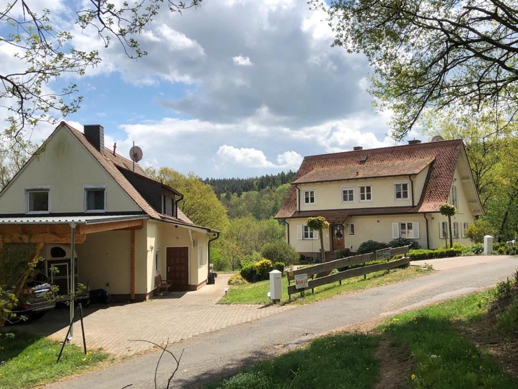 ein großes weißes Haus mit einem Tor und einer Einfahrt in der Unterkunft Ferienwohnung am Rohrbacherhof Sabine Rück in Barackenhöfe